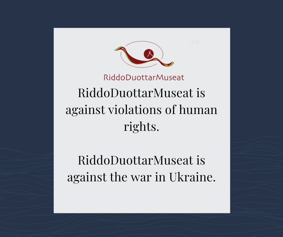 Bilde med tekst i hvit firkant og blå bakgrunn. RiddoDuottarMuseats logo og teksten "RiddoDuottarMuseat is against violations of human rights. RiddoDuottarMuseat is against the war in Ukraine."
