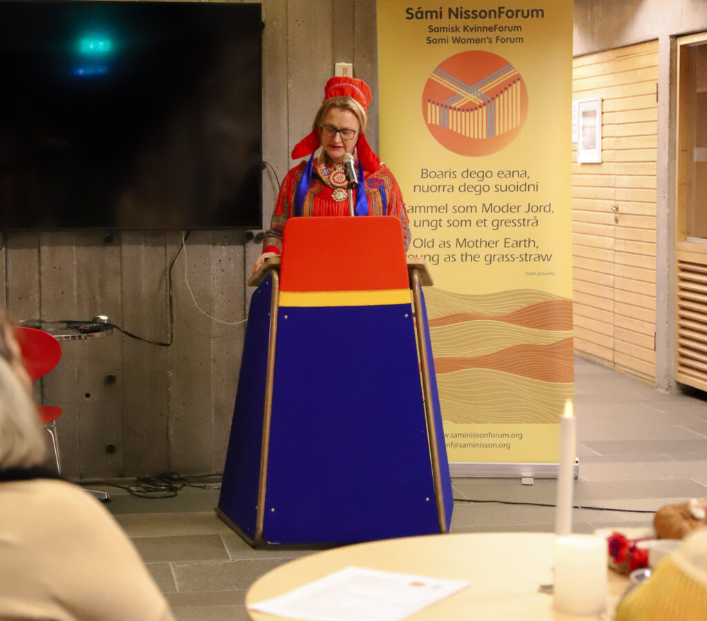 a Sámi woman in traditional clothing having a speech.