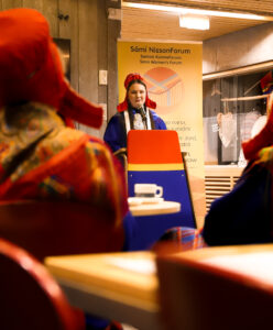 a Sámi woman in traditional clothing having a speech.