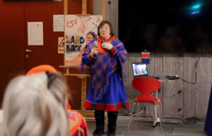 a Sámi woman in traditional clothing having a speech.