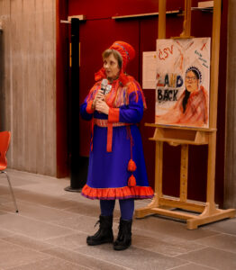 a Sámi woman in traditional clothing having a speech.