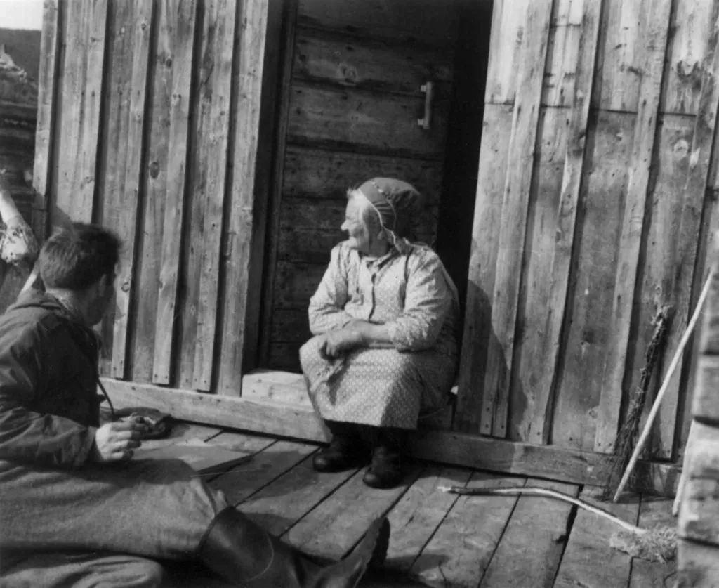 Ravna Vuolab Nikkinen sitter på dørstokken i Jávrebainjárga 1952.